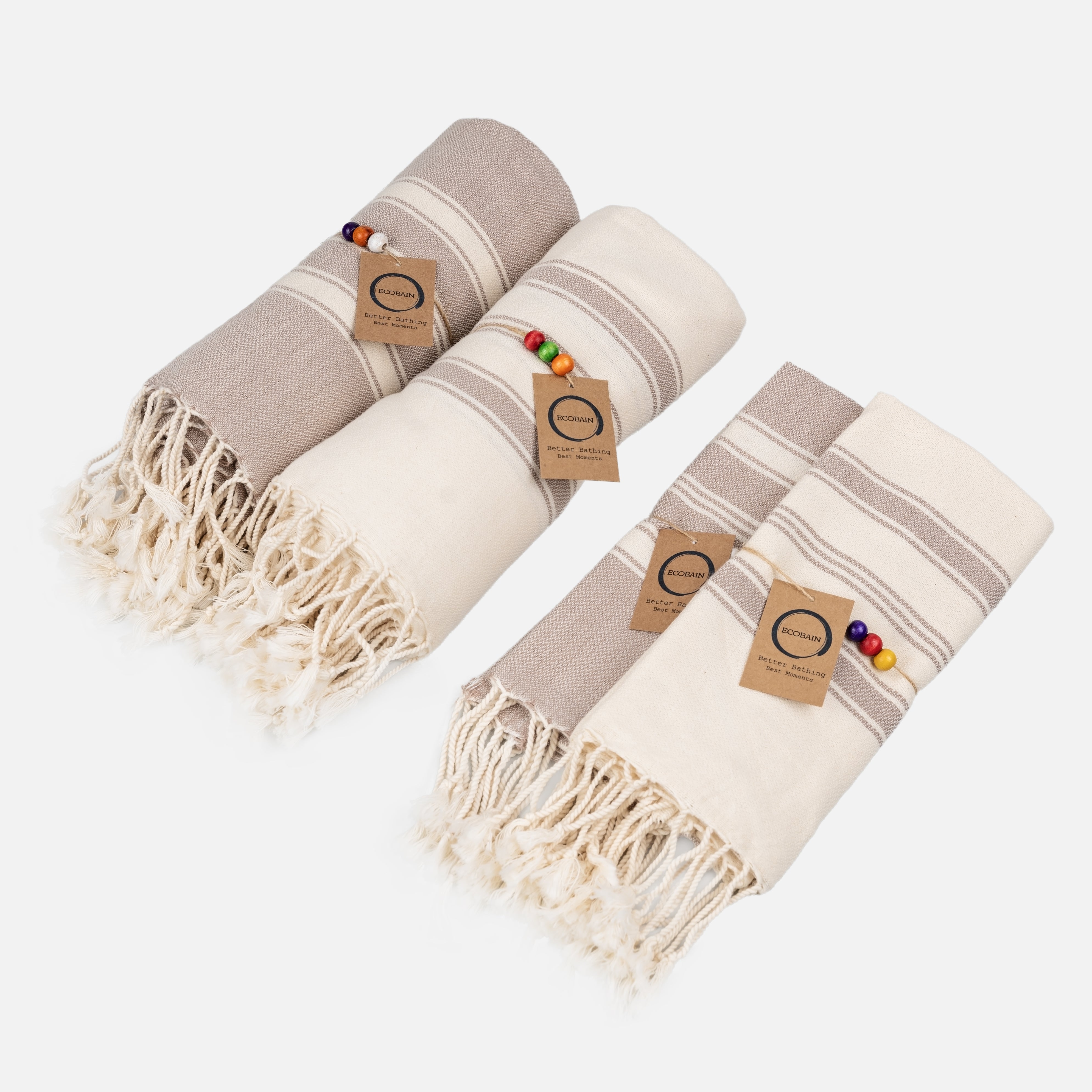 Ecobain Better Together Pack Handtuch-Set in Taupe und Naturweiß. Das vierteilige Hamamtuch-Set aus 100% Naturfasern besteht aus zwei großen Saunatüchern und zwei passenden Gästetüchern mit Fransen, Holzperlen und Hangtag.