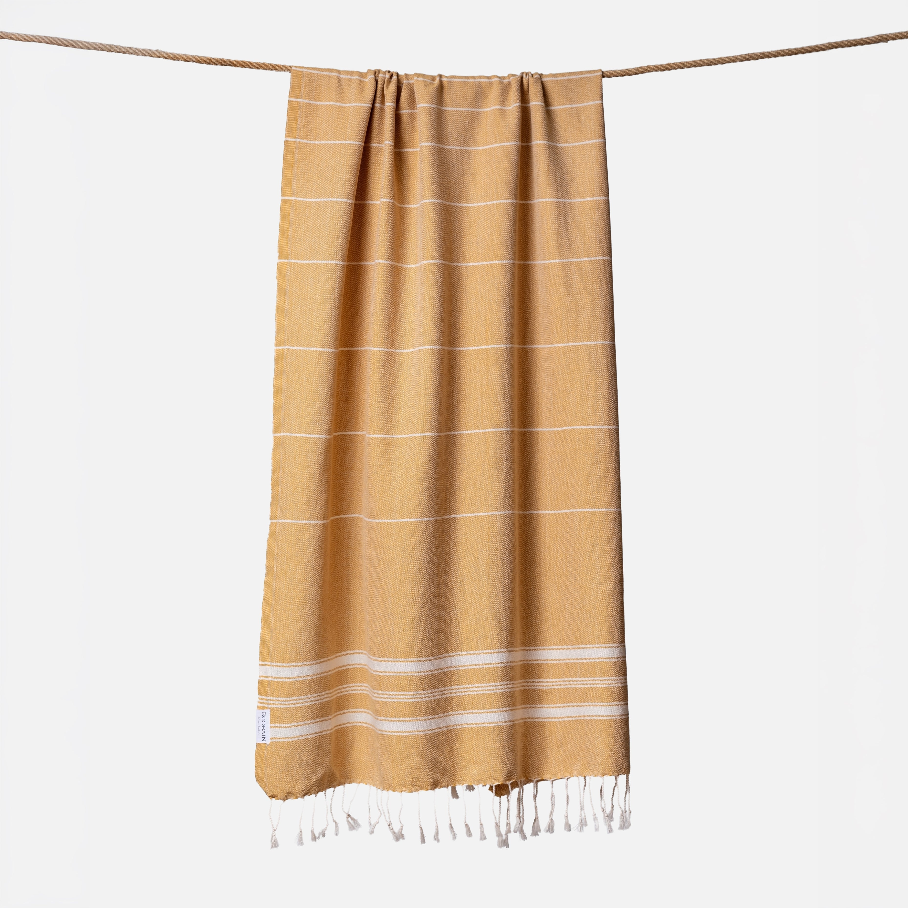 Extragroßes Ecobain Strandtuch der Liberty Series im trendigen Senfgelb Mustard Seed. Das platzsparende Pestemal in 100x200 cm wird stilvoll gerollt mit originalem Hang Tag geliefert und ist die perfekte nachhaltige Geschenkidee für Wellnessliebhaber. Ein absolut sandfreies Reisehandtuch, das höchsten Komfort am Strand oder in der Sauna bietet und schweres Frottee mühelos ersetzt.