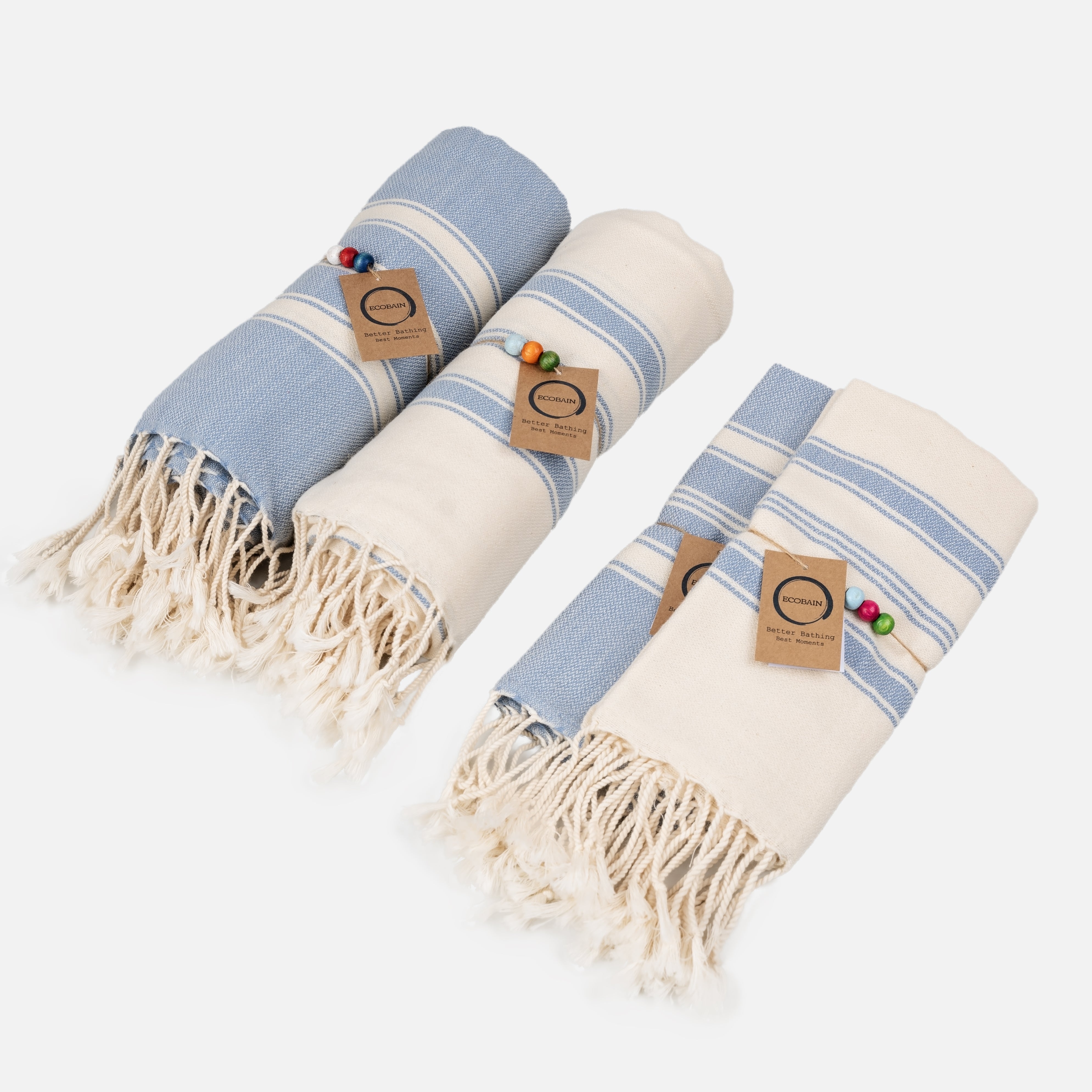 Ecobain Better Together Pack Handtuch-Set in Mittelblau und Naturweiß. Das vierteilige Hamamtuch-Set aus 100% Naturfasern besteht aus zwei großen Saunatüchern und zwei passenden Gästetüchern mit Fransen, Holzperlen und Hangtag.