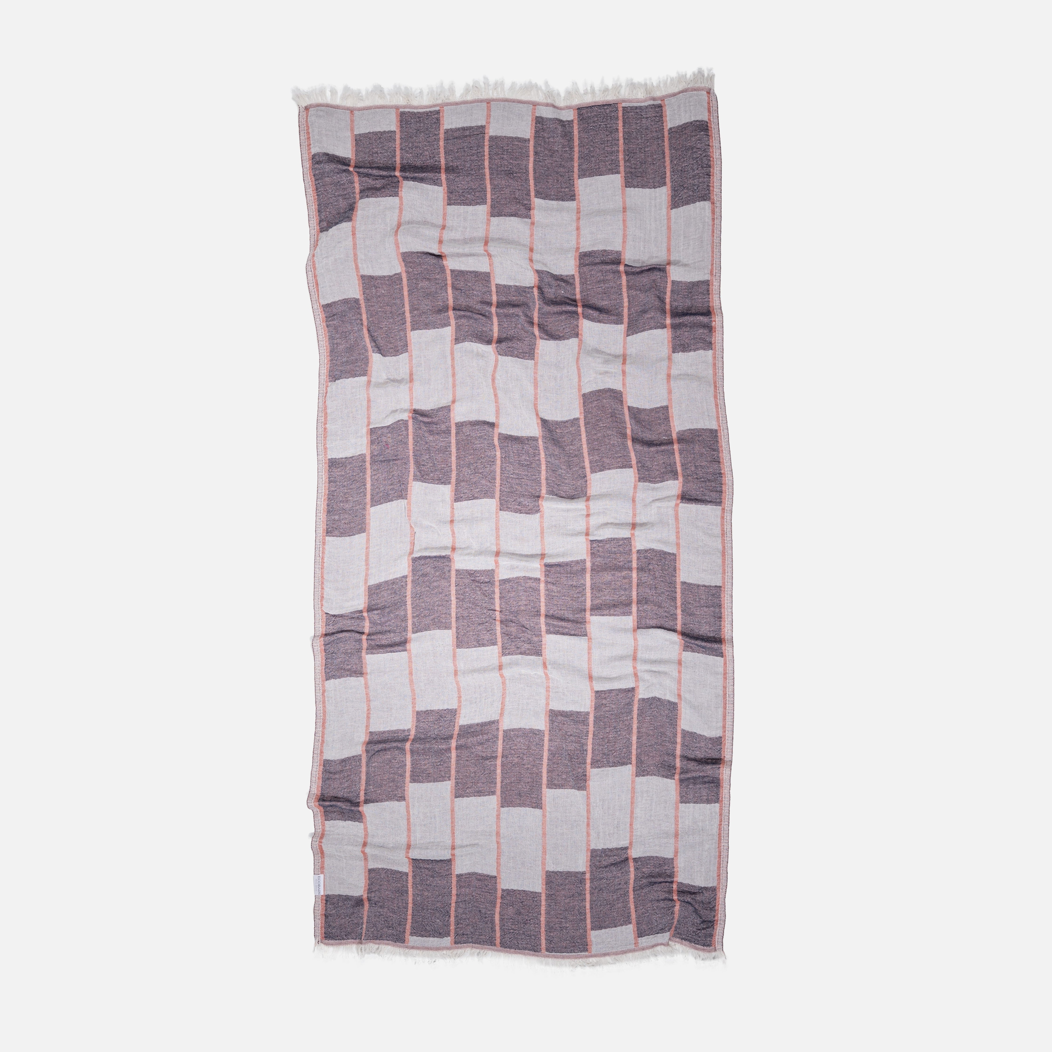 Detailaufnahme des Ecobain Premiumtuchs 'Chess' in der eleganten Farbnuance Burnt Brick. Die handwerklich gewebte Karo-Struktur des weichen Baumwolltuchs vereint traditionelle Qualität mit moderner Leichtigkeit. Ideal als platzsparendes Reisetuch für den Segeltörn, Wellness oder den Sport – ein klares Statement für bewusste, anspruchsvolle Badekultur.