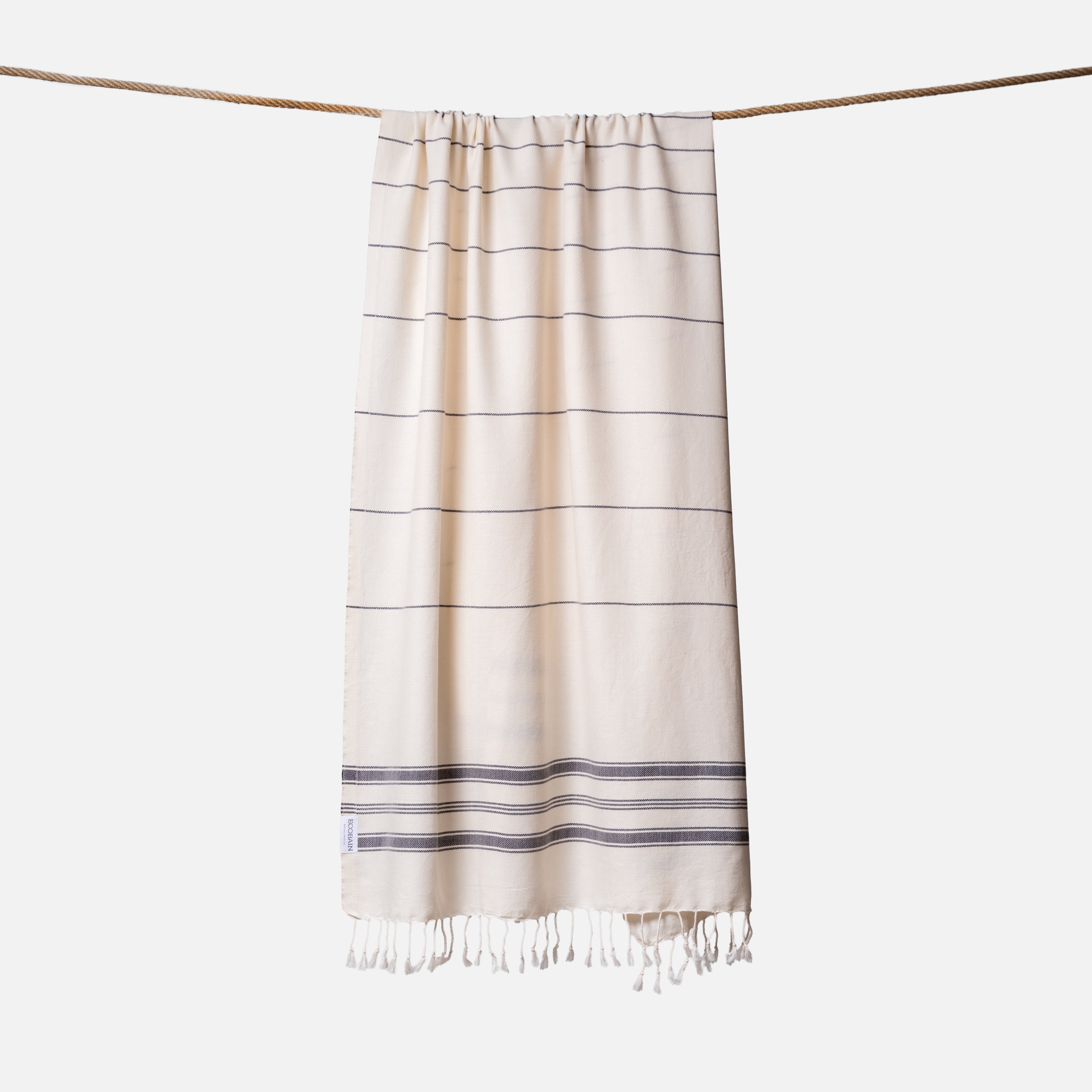 Extragroßes Ecobain Strandlaken der Liberty Series im minimalistischen Design After Dark. Das platzsparende Pestemal in 100x200 cm wird stilvoll gerollt mit originalem Hang Tag geliefert und ist die ideale nachhaltige Geschenkidee für aktive Familien. Ein absolut sandfreies Reisehandtuch aus pestizidfreiem Anbau, das selbst bei großem Gepäck für die ganze Familie die Badetasche federleicht hält und schweres Frottee ersetzt.