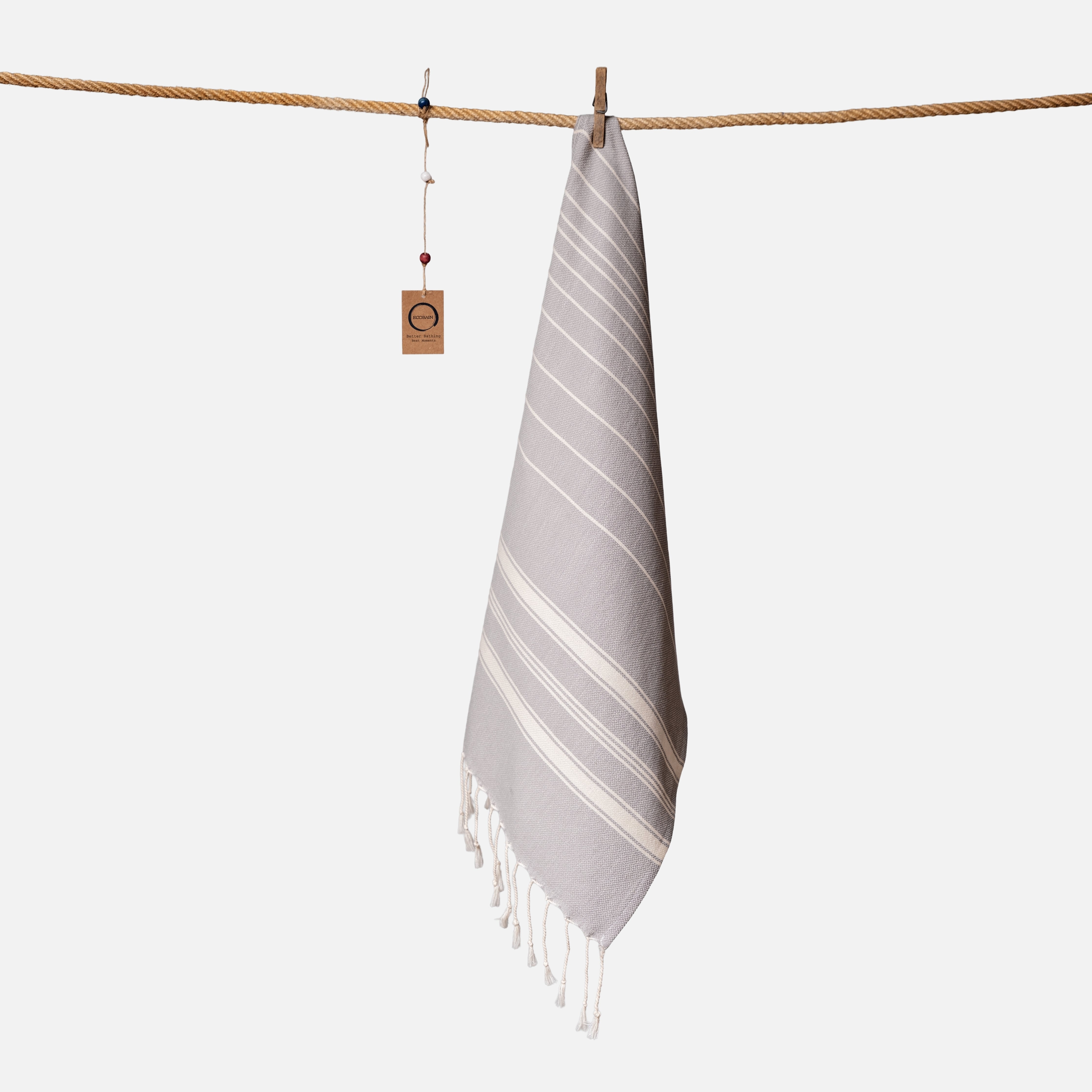Kompaktes Ecobain Reisehandtuch im Design 'New Classic' in der Farbe Moon Shadow. Mit 50x100 cm ist dieses leichte Baumwolltuch aus hochwertiger Faser der ideale Begleiter für Yoga Sessions, das Handgepäck oder als ästhetisches Gesichtstuch im Bad. Ein schnelltrocknendes Hamamtuch, das traditionelle Webkunst mit moderner Leichtigkeit verbindet und deinen Wellness-Alltag bereichert.