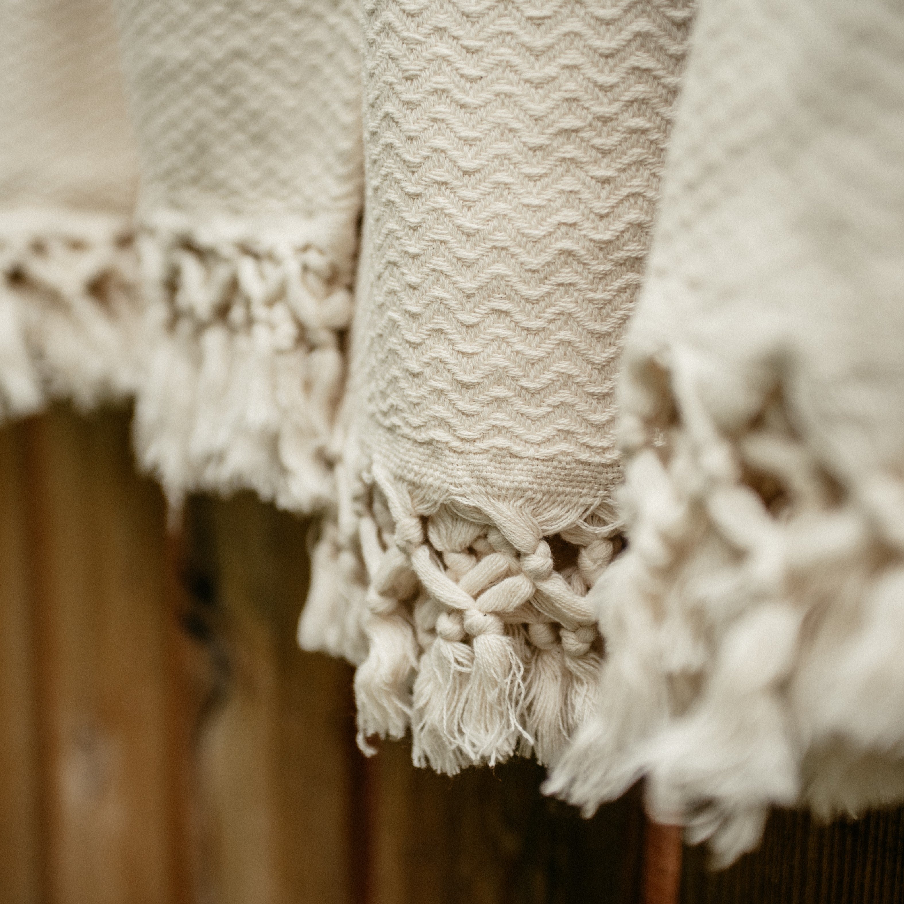 Nahaufnahme der feinen Textur eines blauen Ecobain Gordion Towels, ausgebreitet auf einem Liegestuhl am Pool.