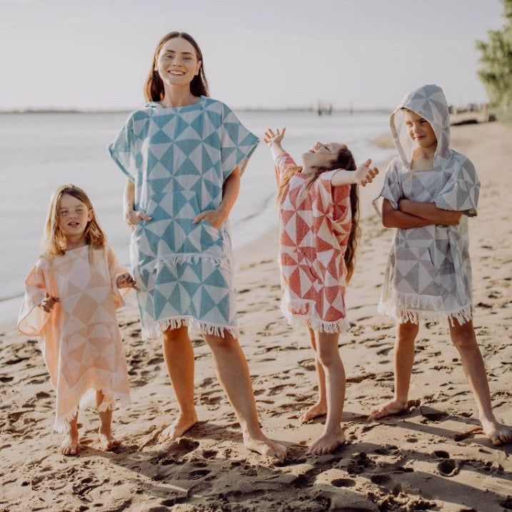 Nahaufnahme des Ecobain Ponchos Symique in Blue Hawaii, die detailliert das voluminöse, doppellagige Jacquard Gewebe an der Kapuze zeigt.