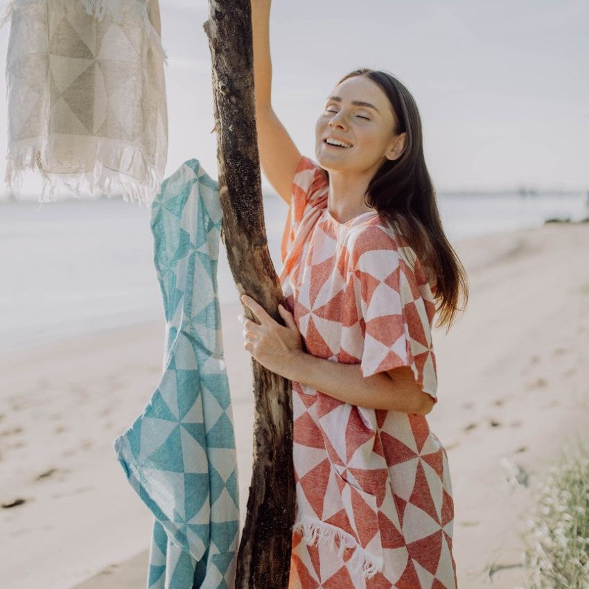 Nahaufnahme des Ecobain Ponchos Symique in Wild Cherry, die das voluminöse, doppellagige Jacquard Gewebe am Ausschnitt zeigt.
